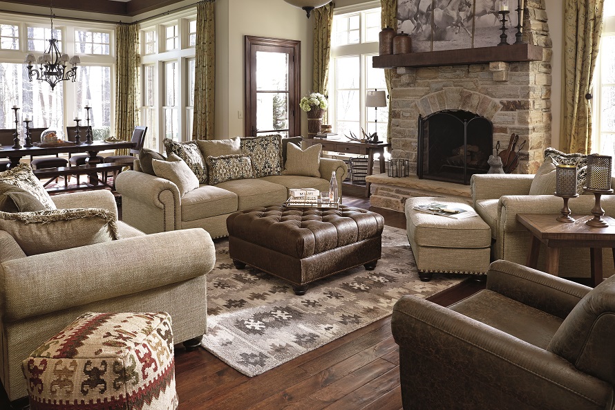 Several neutral and rustic furniture peices in a living room with lots of wood and country elements.